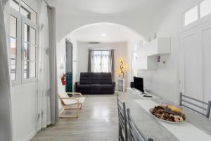 a kitchen and living room with a black couch at Casa Pereira in Ponta do Pargo