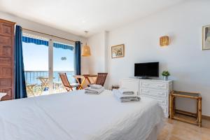 a bedroom with a bed and a television and a table at Ventana al mar in Fuengirola