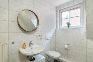 ein Badezimmer mit Waschbecken, Toilette und Spiegel in der Unterkunft Aposto Apartments 3 in Oberderdingen + 14 Fotos