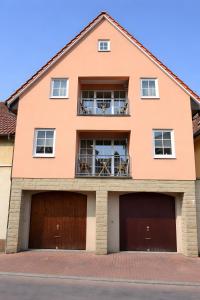 ein großes orangefarbenes Haus mit zwei Garagentoren in der Unterkunft Aposto Apartments 3 in Oberderdingen