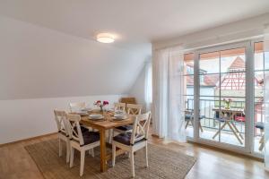 ein Esszimmer mit Tisch und Stühlen und einem Balkon in der Unterkunft Aposto Apartments 3 in Oberderdingen