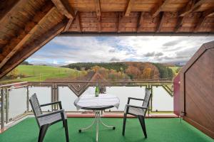 a table and chairs on a balcony with a view at Pension Deutscher Hof in Oberbiederbach