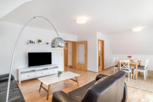 ein Wohnzimmer mit Sofa und Fernseher in der Unterkunft Aposto Apartments 3 in Oberderdingen