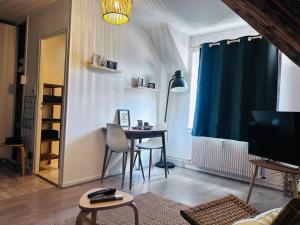 a living room with a table and a blue curtain at Studio Pergaud in Besançon
