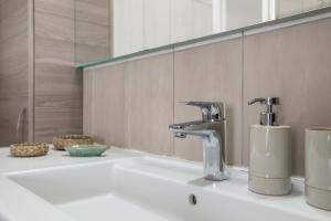 a bathroom sink with a faucet and a mirror at Casa Steffi in Arona +16 photos