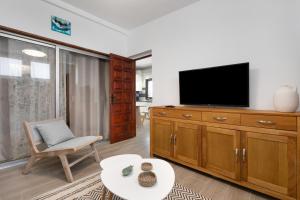 a living room with a tv and a chair and a table at Casa Steffi in Arona