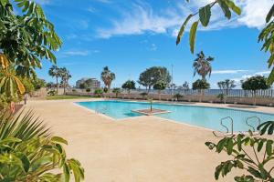 a swimming pool in the middle of a yard with trees at Edificio Los Martines in El Médano