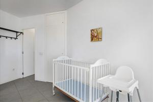 two white chairs and a crib in a room at Edificio Los Martines in El Médano +19 photos
