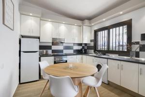a kitchen with a wooden table and white cabinets at Casa Steffi in Arona