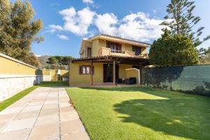 a house with a lawn in front of it at Villa Balbi in Torre delle Stelle