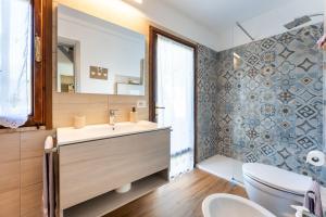 a bathroom with a sink and a toilet and a mirror at Villa Balbi in Torre delle Stelle +30 photos