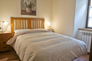 a large bed in a bedroom with two lamps at Ço de Carles in Garós