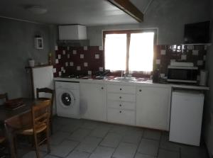 a kitchen with a stove and a sink and a dishwasher at Gîte Champêtre, Tout Confort in Saint-Éloy-la-Glacière