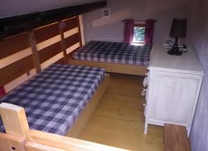 a room with two beds and a table and a desk at Gîte Champêtre, Tout Confort in Saint-Éloy-la-Glacière