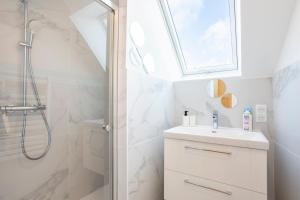 a white bathroom with a sink and a shower at Ty Sterenn - 400m de la plage in Le Guilvinec +17 photos