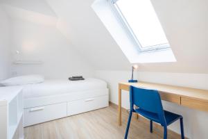 a bedroom with a bed and a desk and a blue chair at Ty Sterenn - 400m de la plage in Le Guilvinec