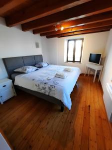 a bedroom with a large bed with a wooden floor at Chambre et Table d’Hôtes du Terroir in Borne