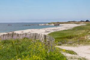 a sandy beach with a fence and the ocean at Ty Sterenn - 400m de la plage in Le Guilvinec