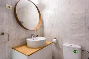 a bathroom with a sink and a mirror and a toilet at Plata Centro in Torremolinos +12 photos
