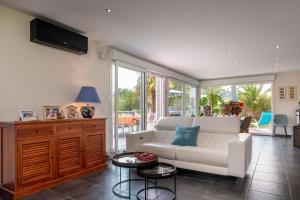 a living room with a white couch and some windows at Côté Vannes in Ploeren