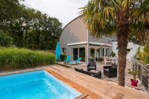 a backyard with a swimming pool and a house at Côté Vannes in Ploeren