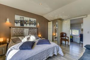a bedroom with a large bed and a chair at Villa Angelo - Olive Verte in Saint-Thibéry +23 photos