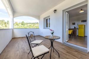 a living room with a table and chairs and a window at New and Vintage Villa - Anni 70' in Alghero
