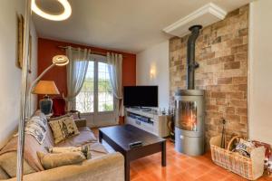 a living room with a couch and a fireplace at Villa Angelo - Olive Verte in Saint-Thibéry