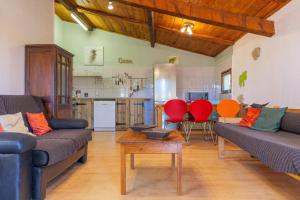 a living room with two couches and a kitchen at Gîte Des Louveteaux in Banne