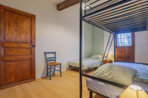 a bedroom with a bunk bed and a chair at Gîte Des Louveteaux in Banne