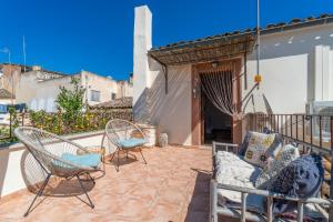a patio with chairs and a couch on a patio at Casa Llimoner con piscina in Sant Llorenç des Cardassar