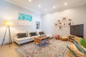 a living room with a white couch and a tv at Casa Llimoner con piscina in Sant Llorenç des Cardassar