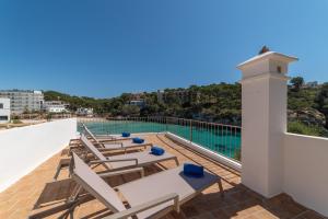 a balcony with lounge chairs and a swimming pool at Sa Barca - Can Ferrando in Cala Santanyi
