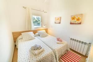 a bedroom with two twin beds and a window at Sa Barca - Can Ferrando in Cala Santanyi