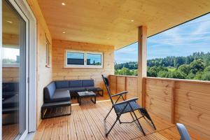 a screened in porch with a couch and chairs at Mettmapark - Chalet 1 in Grafenhausen
