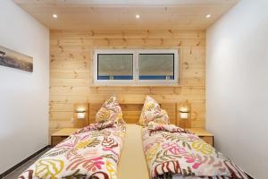 two beds in a small room with wooden walls at Mettmapark - Chalet 1 in Grafenhausen