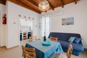 a living room with a blue couch and a table at Casa Del Pescatore in Trappeto