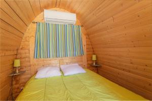 a small bed in a wooden room with a window at Pod Anis in Saint-André