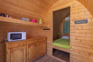 a cabin with a microwave and a bed in it at Pod Anis in Saint-André +8 photos