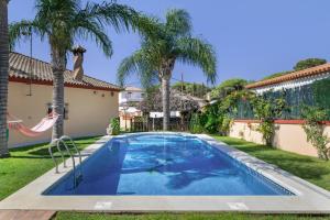 a swimming pool in the backyard of a house with palm trees at Casa La Muela in La Muela