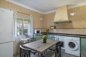a kitchen with a table and chairs and a washer at Casa La Muela in La Muela