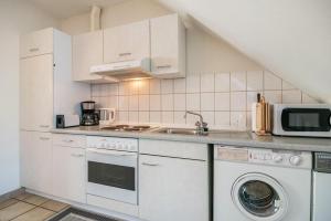 a kitchen with white cabinets and a washer and dryer at Ferienwohnung 4 in Bernkastel-Kues +10 photos