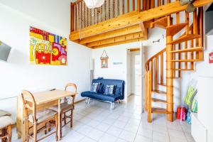 a room with a wooden staircase and a table and chairs at La Cabine du Marin - 73 in Pornic