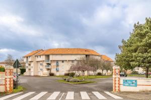 a building with an orange roof in a parking lot at La Cabine du Marin - 73 in Pornic