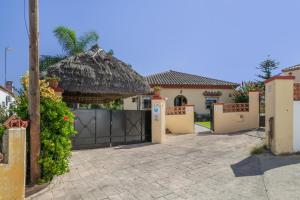 a house with a gate and a thatch roof at Casa La Muela in La Muela