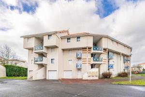 a building with balconies in a parking lot at La Cabine du Marin - 73 in Pornic +12 photos