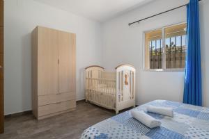 a bedroom with a crib and a bed and a cabinet at Casa La Muela in La Muela +20 photos