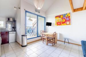 a kitchen and dining room with a table and a window at La Cabine du Marin - 73 in Pornic