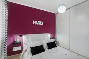 a bedroom with a purple accent wall and a bed at Apartamento Porís in Arico +13 photos