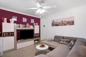 a living room with a couch and a flat screen tv at Apartamento Porís in Arico